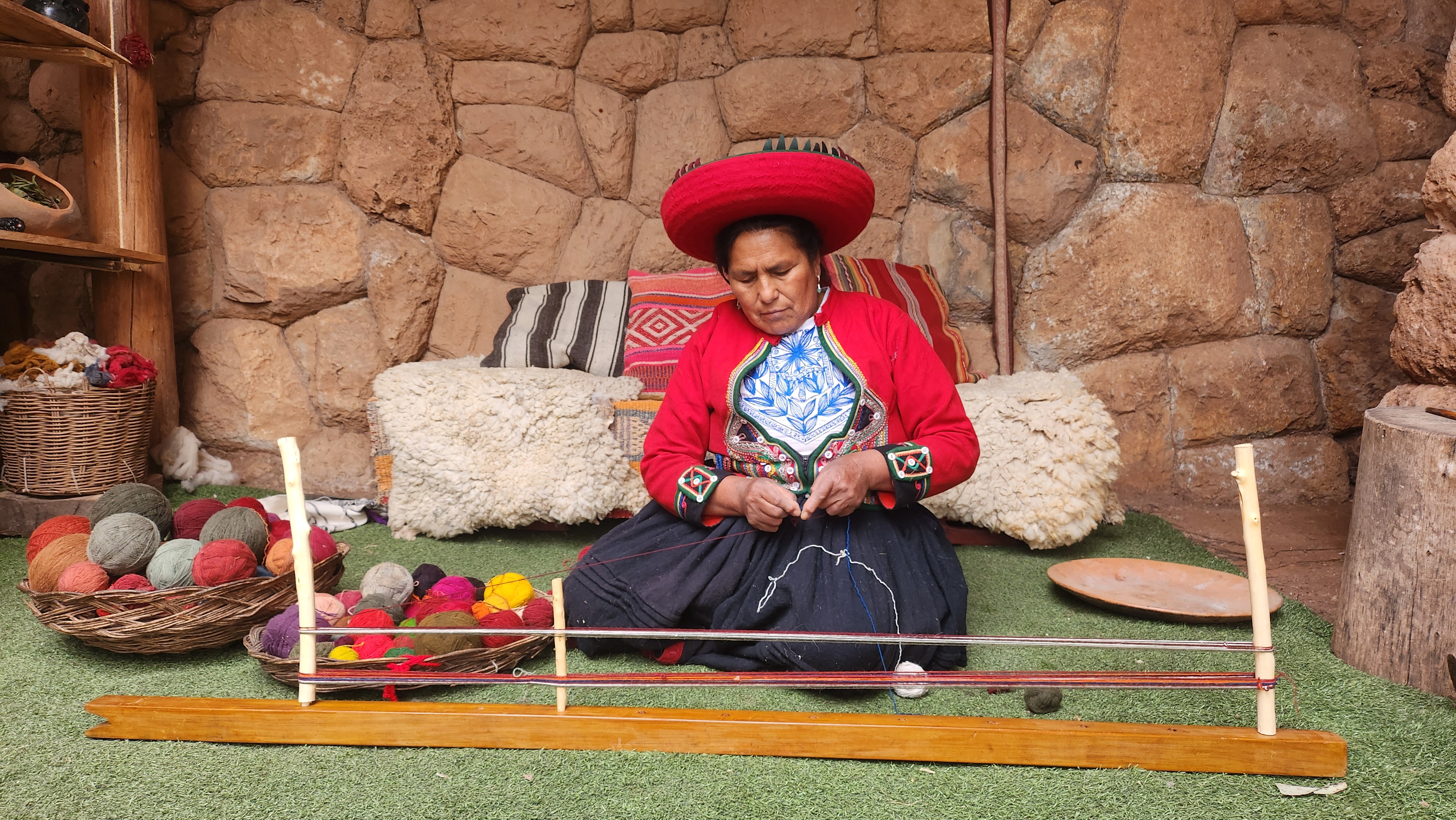 Chinchero weaver spinning wool in the workshop courtyard